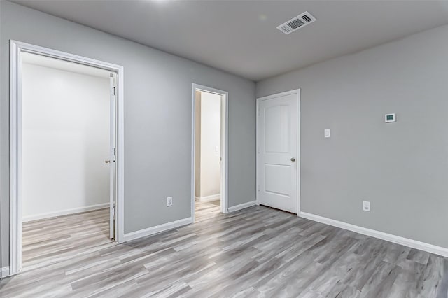 unfurnished bedroom featuring light hardwood / wood-style flooring and a closet