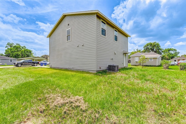 view of home's exterior with central AC unit and a lawn