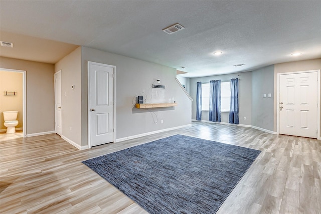 living room with light wood-type flooring and a textured ceiling