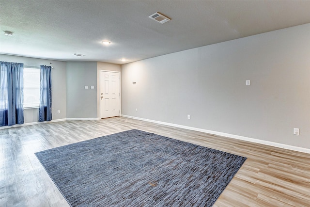 spare room with wood-type flooring and a textured ceiling