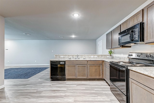 kitchen featuring light hardwood / wood-style floors, sink, black appliances, and kitchen peninsula