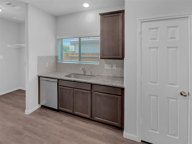 kitchen with stainless steel dishwasher, decorative backsplash, sink, and dark brown cabinetry