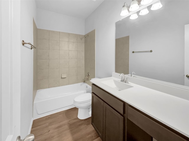 full bathroom featuring toilet, tiled shower / bath, wood-type flooring, and vanity