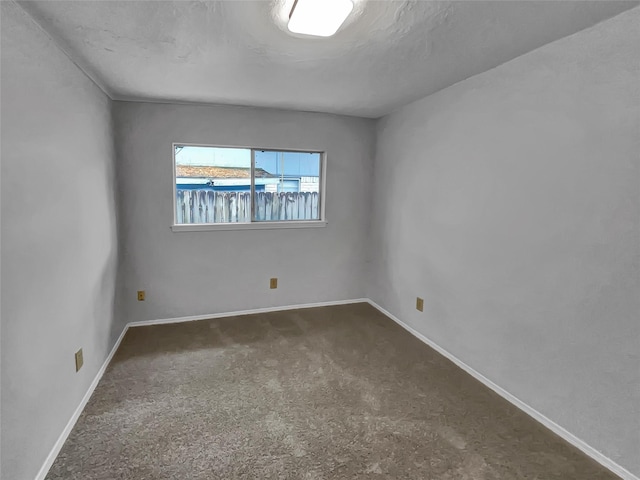 unfurnished room featuring dark colored carpet