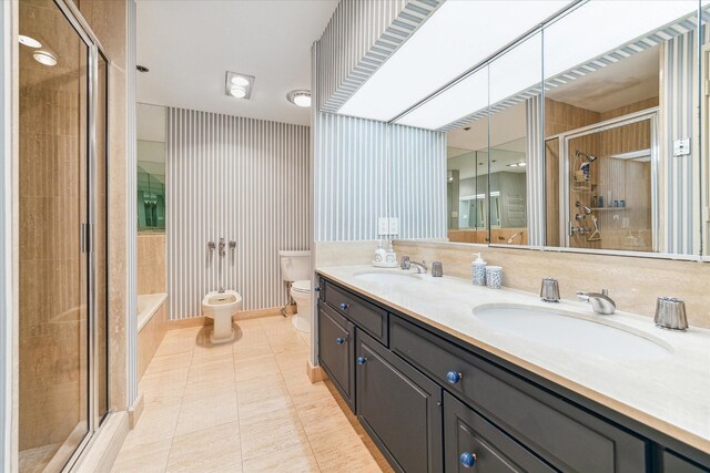 bathroom with a bidet, toilet, dual bowl vanity, and tile patterned floors