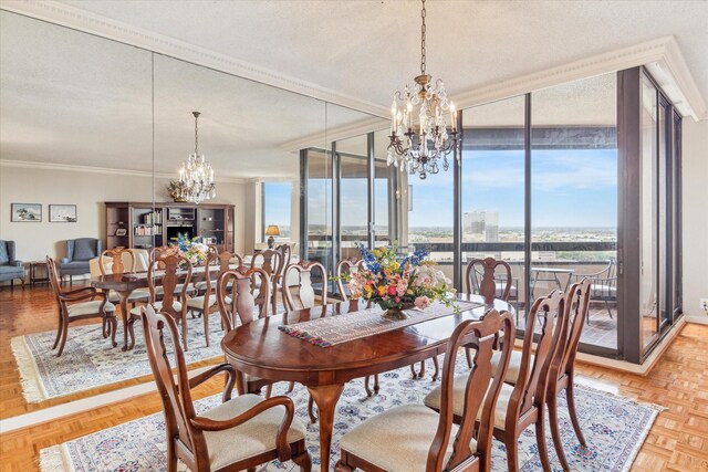 dining space with a chandelier, light parquet flooring, ornamental molding, a textured ceiling, and expansive windows