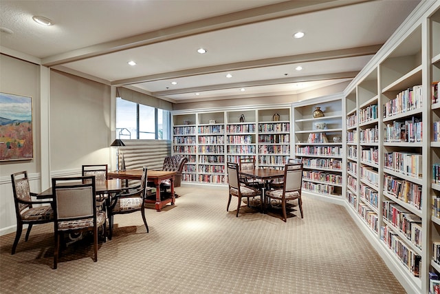 interior space with beam ceiling and light colored carpet