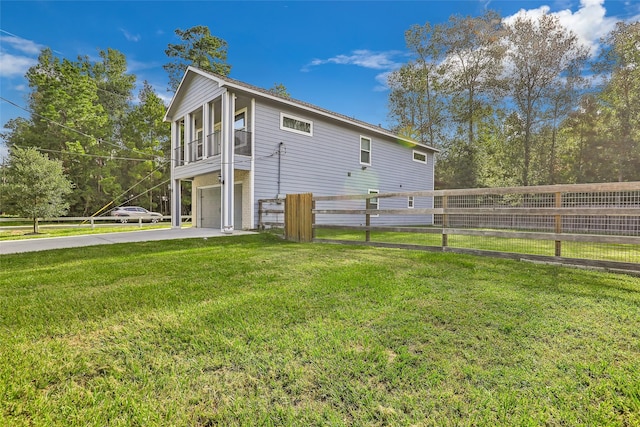 rear view of house featuring a garage and a lawn