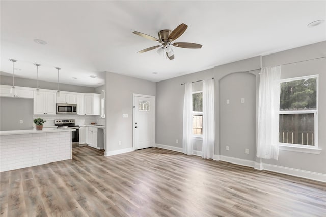 unfurnished living room with ceiling fan and light hardwood / wood-style flooring