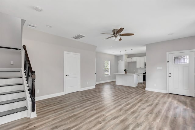 unfurnished living room featuring light hardwood / wood-style floors and ceiling fan