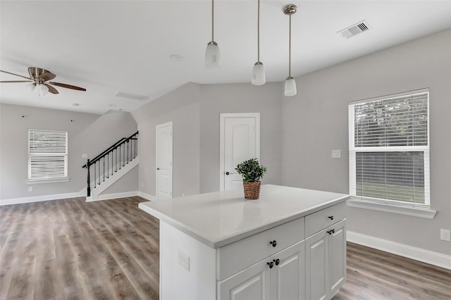 kitchen with ceiling fan, a center island, dark wood-type flooring, pendant lighting, and white cabinets