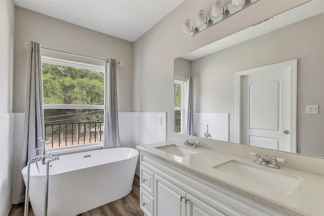 bathroom with a tub, a wealth of natural light, and hardwood / wood-style flooring