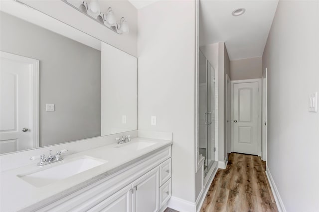 bathroom with vanity, hardwood / wood-style flooring, and a shower with shower door