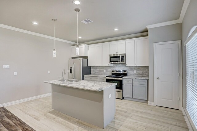 kitchen featuring white cabinetry, a kitchen island with sink, hanging light fixtures, appliances with stainless steel finishes, and ornamental molding