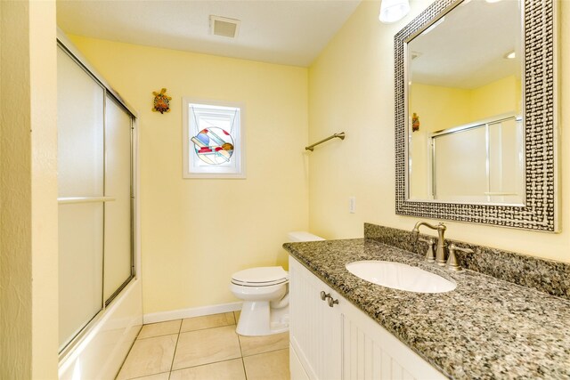 full bathroom featuring vanity, toilet, tile patterned floors, and enclosed tub / shower combo