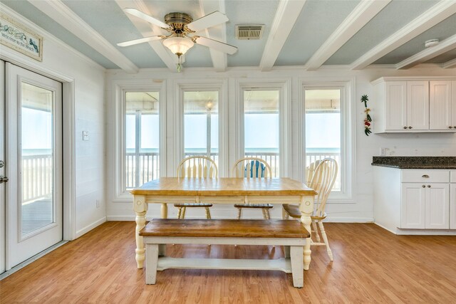 dining room featuring ceiling fan, light hardwood / wood-style flooring, a wealth of natural light, and beam ceiling