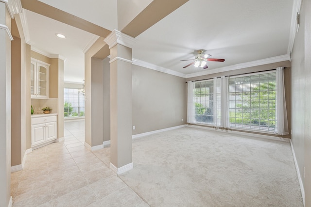 carpeted spare room with ceiling fan, ornamental molding, and decorative columns