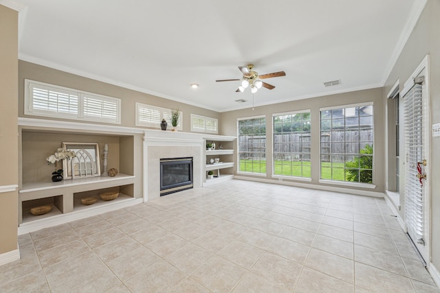 unfurnished living room featuring ornamental molding, a tile fireplace, and light tile patterned floors