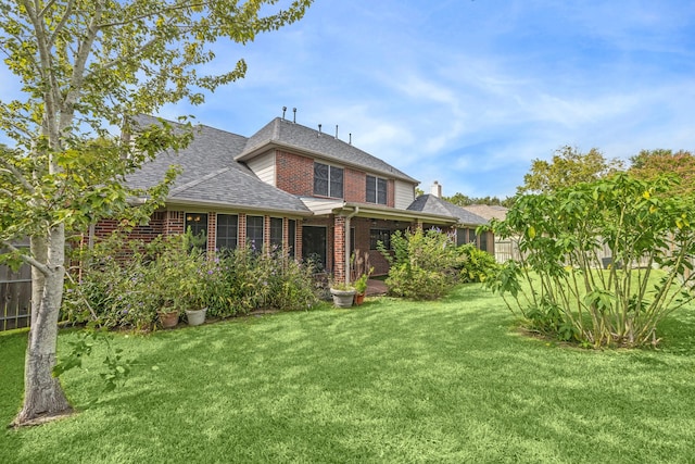 rear view of property with a lawn