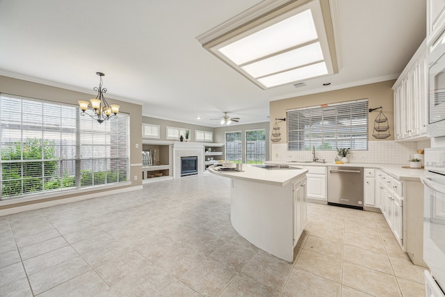 kitchen with tasteful backsplash, white cabinetry, a kitchen island, decorative light fixtures, and stainless steel dishwasher