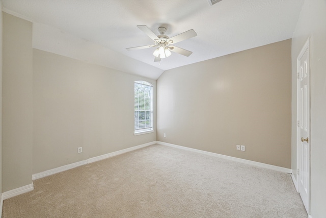 carpeted empty room with vaulted ceiling and ceiling fan