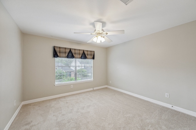 carpeted spare room featuring ceiling fan