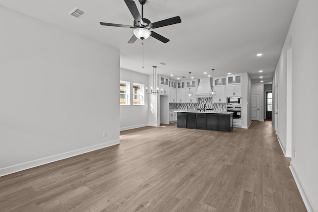 unfurnished living room with hardwood / wood-style floors and ceiling fan with notable chandelier