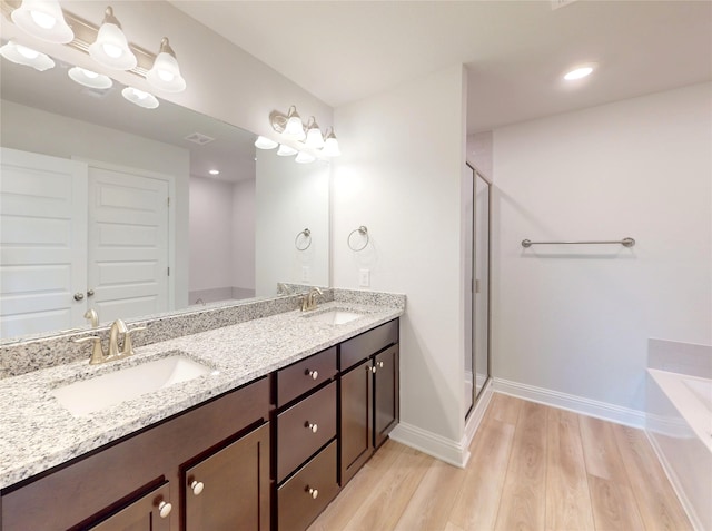 19910 Paros Island Dr, Hockley, TX 77447 - bathroom with a sink, baseboards, a stall shower, and wood finished floors