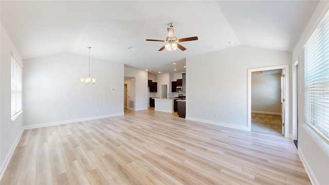19910 Paros Island Dr, Hockley, TX 77447 - unfurnished living room with baseboards, lofted ceiling, light wood-style floors, and ceiling fan with notable chandelier