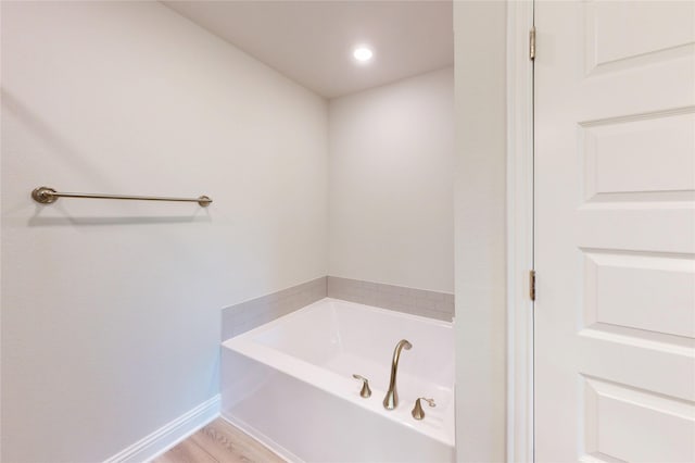 19910 Paros Island Dr, Hockley, TX 77447 - bathroom with a bath, wood finished floors, and baseboards