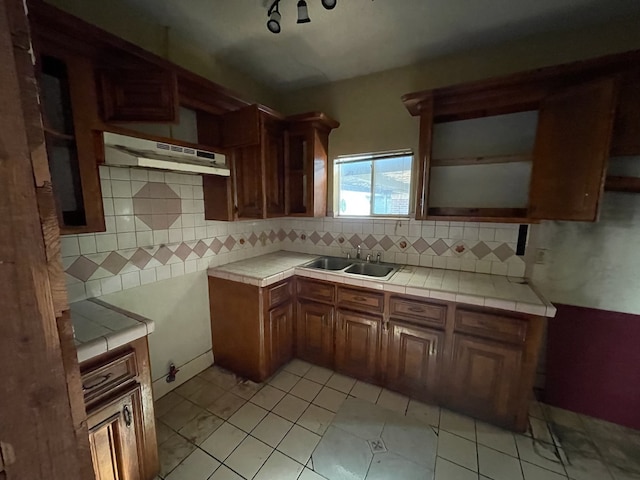 kitchen with tile countertops, tasteful backsplash, and sink