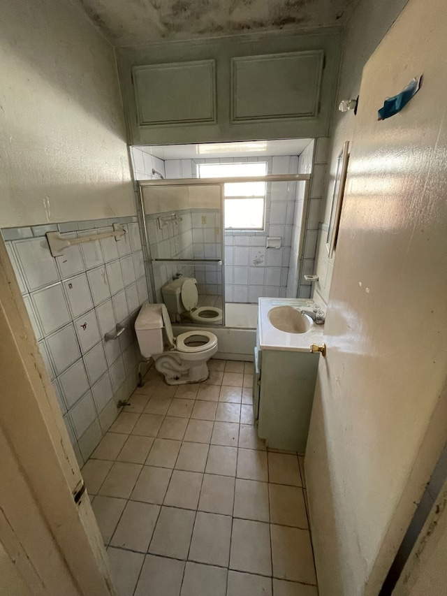 bathroom featuring tile patterned flooring, vanity, tile walls, and toilet