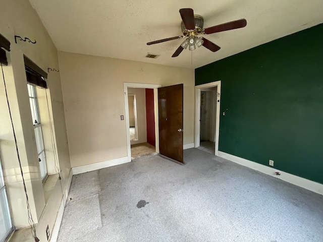 unfurnished bedroom with ceiling fan and a textured ceiling