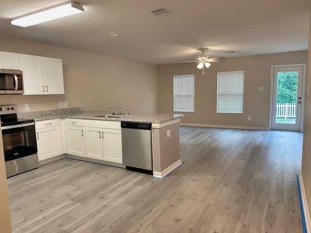 kitchen featuring sink, light hardwood / wood-style flooring, kitchen peninsula, stainless steel appliances, and white cabinets