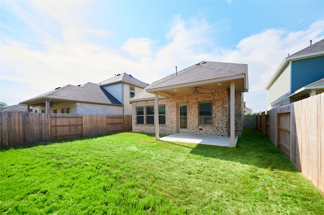 rear view of property featuring a lawn, ceiling fan, and a patio