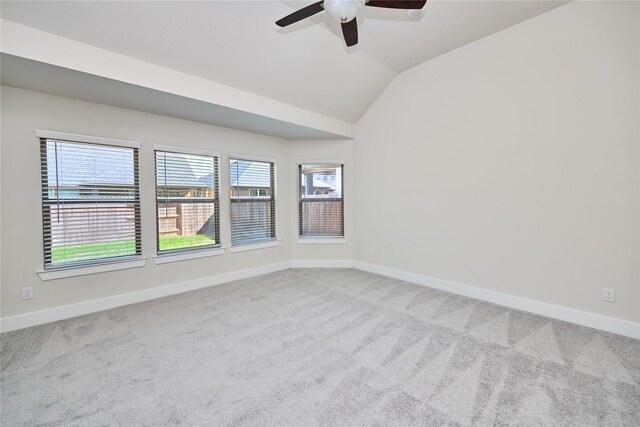 carpeted spare room featuring ceiling fan and vaulted ceiling