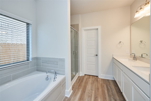 bathroom featuring hardwood / wood-style floors, vanity, and shower with separate bathtub