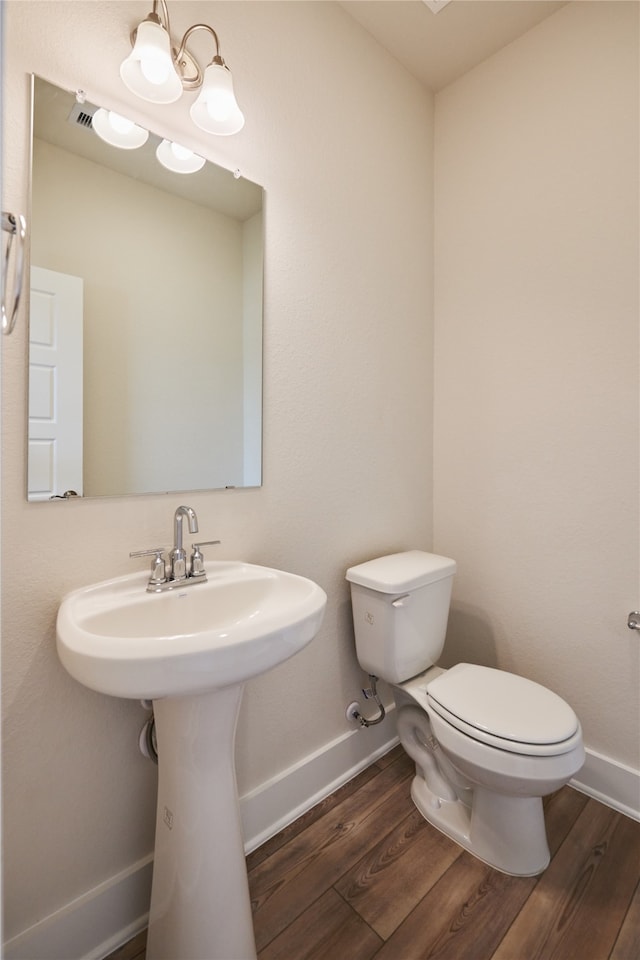 bathroom featuring sink, wood-type flooring, and toilet