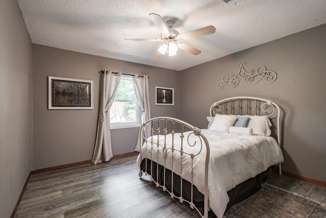 bedroom with hardwood / wood-style flooring, a textured ceiling, and ceiling fan