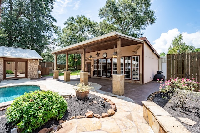 view of patio / terrace with french doors, a fenced in pool, and ceiling fan