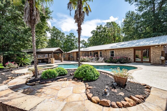 view of swimming pool with a patio and french doors