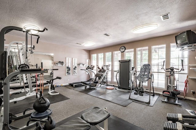 workout area with carpet and a textured ceiling