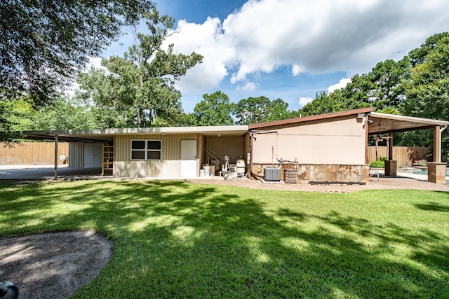 back of house featuring central air condition unit, a patio area, and a lawn