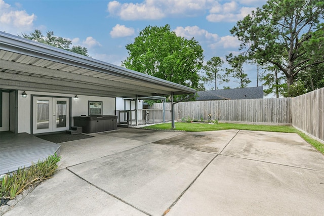 view of patio featuring french doors, a fenced backyard, and a hot tub