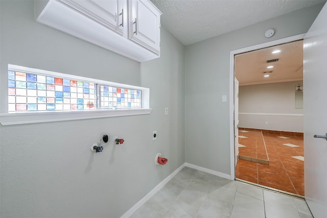 laundry room with cabinet space, light tile patterned floors, baseboards, visible vents, and electric dryer hookup