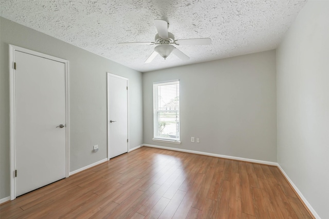 interior space featuring a textured ceiling, baseboards, and wood finished floors