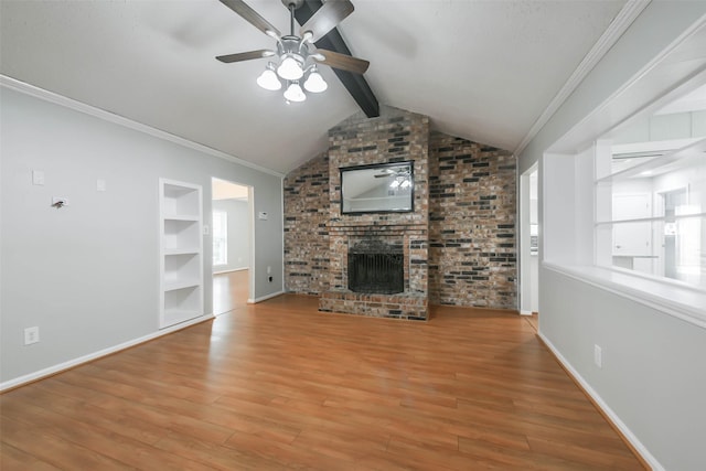 unfurnished living room featuring built in features, lofted ceiling with beams, a brick fireplace, wood finished floors, and baseboards