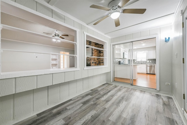 unfurnished sunroom with a sink and a ceiling fan