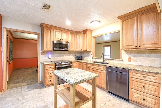 36920 Cougar Dr, Simonton, TX 77476 - kitchen featuring visible vents, a sink, light stone counters, stainless steel appliances, and light tile patterned floors