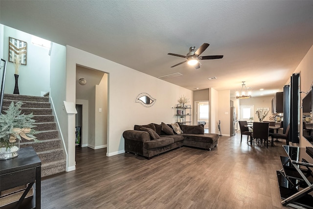 living room with ceiling fan with notable chandelier, dark hardwood / wood-style flooring, and a textured ceiling